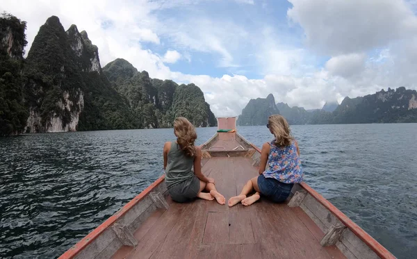 Uzun kuyruklu iki genç kadın gezgin, Tayland 'da gezintiye çıkan maceraperest kız turist ile Cheow Lan Gölü' nde gezintiye çıkıyor.