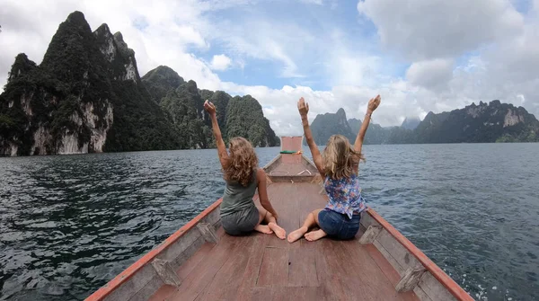 Uzun kuyruklu iki genç kadın gezgin, Tayland 'da gezintiye çıkan maceraperest kız turist ile Cheow Lan Gölü' nde gezintiye çıkıyor.