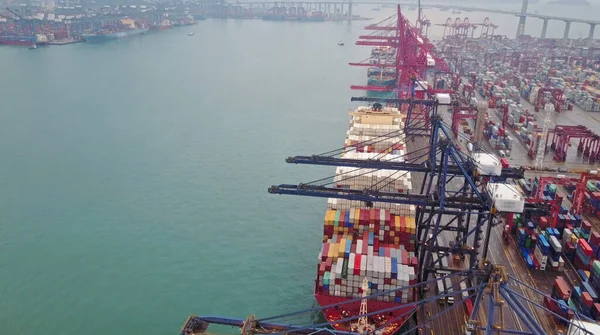 Desfocado todas as marcas visíveis. Vista aérea de enorme porto industrial com contêineres e navio enorme. — Fotografia de Stock