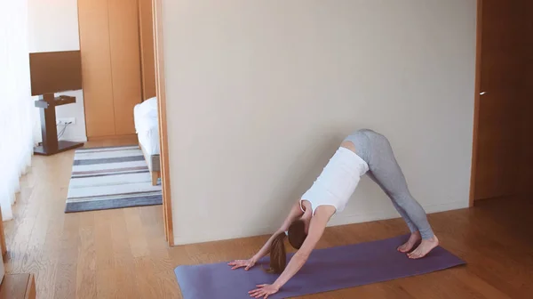 Fit mulher fazendo ioga no tapete em casa no quarto. conceito estilo de vida — Fotografia de Stock