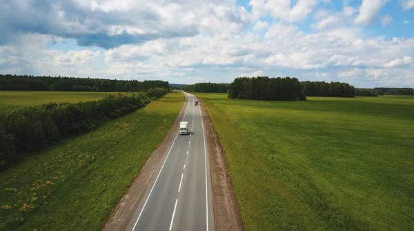 Güzel bir manzara, otoyolda bir gezinti kamyonlar ve gün batımında birkaç araba. hava görünümü