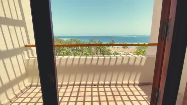 Cámara móvil a través de la ventana al balcón en la casa de playa de lujo con terraza con vistas al mar de diseño moderno. — Vídeos de Stock