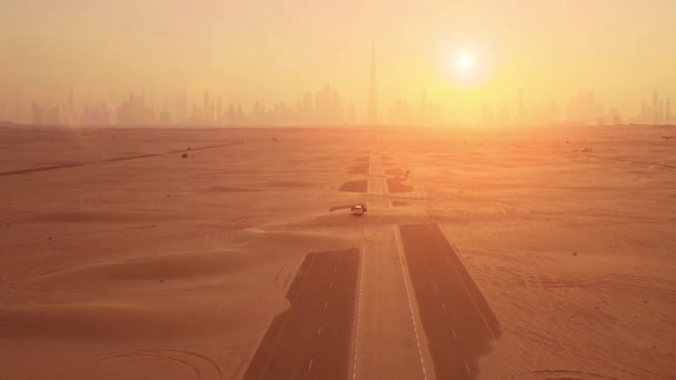 Воздушный выстрел. Пара в машине, стоит на дороге после песчаной бури. Силуэт города Дубай на закате. — стоковое видео