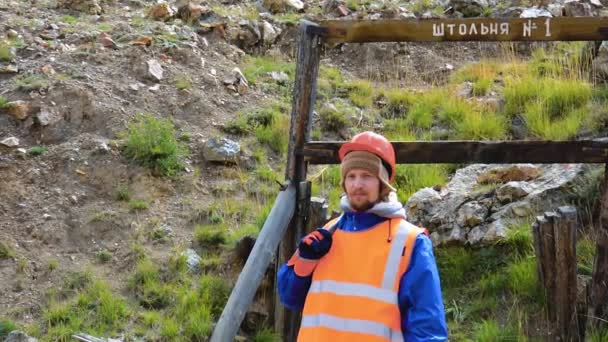 Gruvingenjör, geolog i skyddsväst, handskar och hjälm, med hammare i handen. — Stockvideo