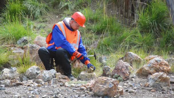 手袋、ヘルメット、反射ウエストコートを身に着けている鉱山技術者または地質学者 — ストック動画