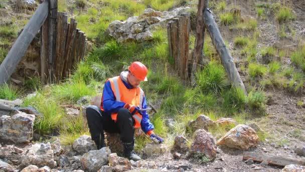 En gruvingenjör eller geolog med handskar, hjälm, reflekterande väst — Stockvideo