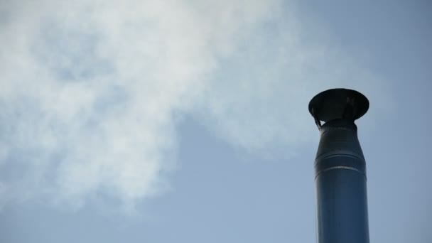 Fumée de la cheminée de la maison le jour d'hiver contre le ciel bleu — Video