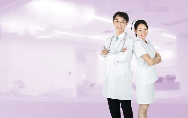Portrait of male doctor and female nurse in uniform standing and smiling — Stock Photo, Image