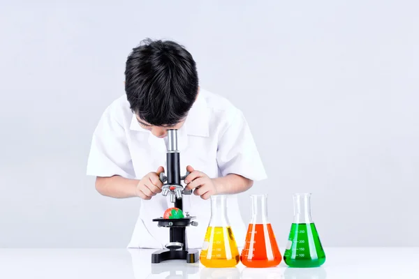 Chłopiec azjatyckich prowadzenia eksperymentu mikroskopu — Zdjęcie stockowe