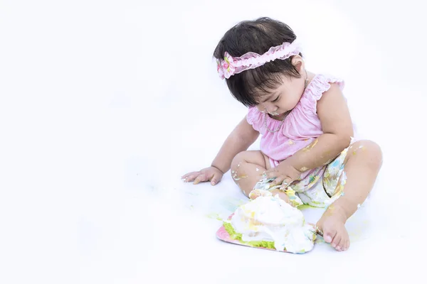 Asiatische baby schmieren Kuchen auf weißem Hintergrund — Stockfoto
