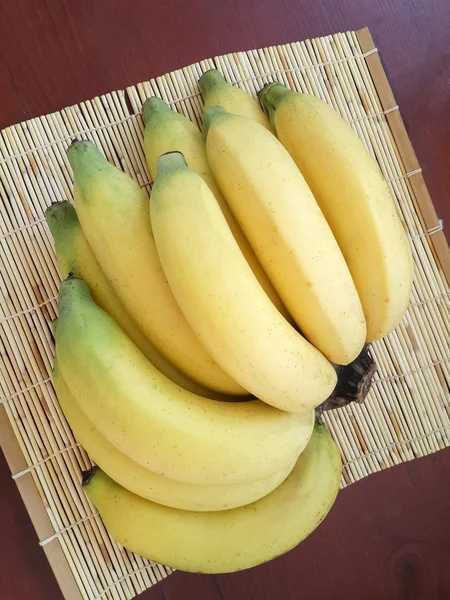 Plátano amarillo maduro en estera de mimbre — Foto de Stock