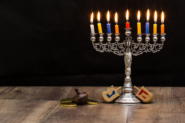 Dreidels and a menorah for Hanukkah. Text-Israel