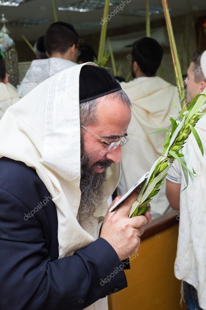 Man holding the four species in the synagogue. Sukkot