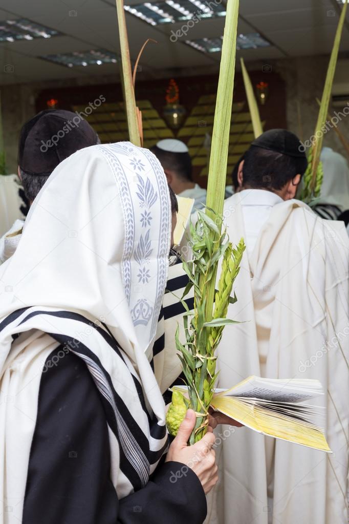 Sukkot . Man holding a lulav and etrog in synagogue