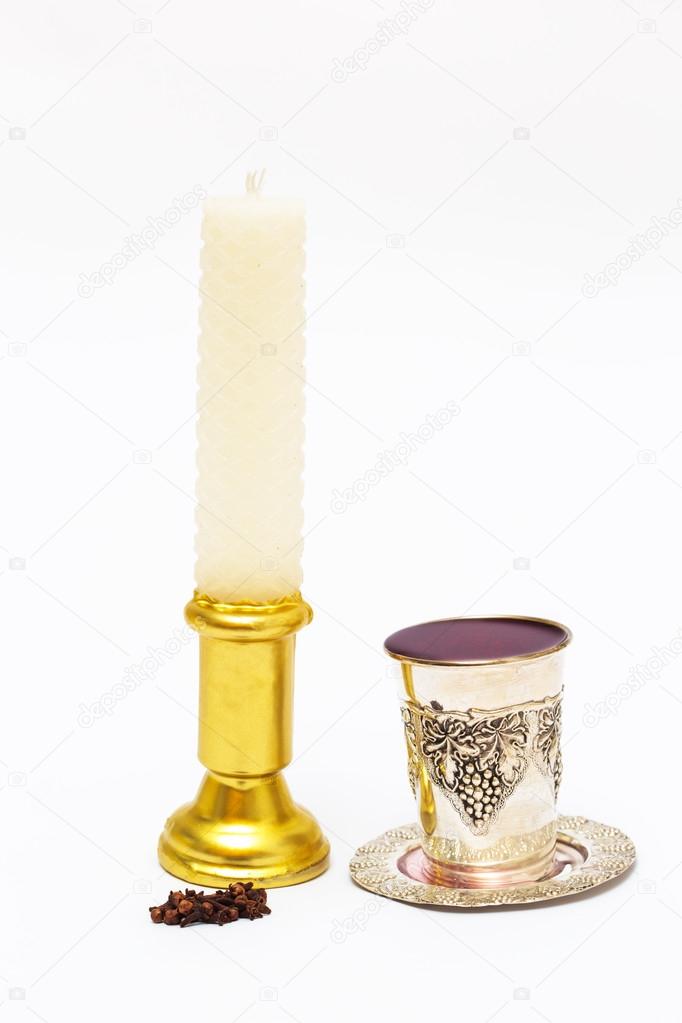 Wax candle with a glass of wine and fragrant cloves. Havdalah.