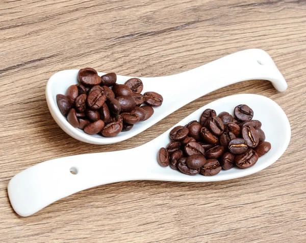 Kaffee, Kaffeebohnen auf weißem Keramiklöffel — Stockfoto