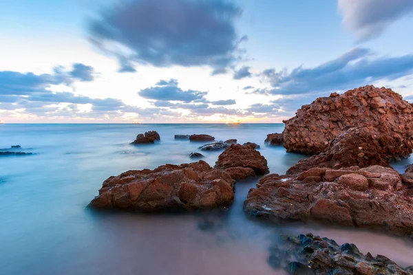 Enorme rotsblokken op het strand op een bewolkte dag — Stockfoto