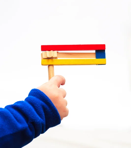 Main d'un enfant tenant en bois coloré bruyant vacances Pourim — Photo