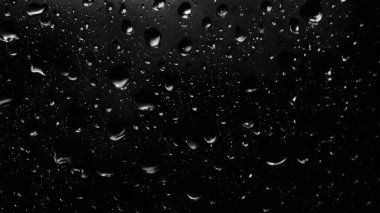 Islak cam. Su damlacıkları. Kapalı camlara yağmur damlaları düşer. Seçici odak siyah ve beyaz
