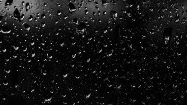 Islak cam. Su damlacıkları. Kapalı camlara yağmur damlaları düşer. Seçici odak siyah ve beyaz
