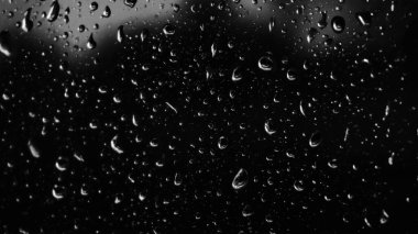 Islak cam. Su damlacıkları. Kapalı camlara yağmur damlaları düşer. Seçici odak siyah ve beyaz