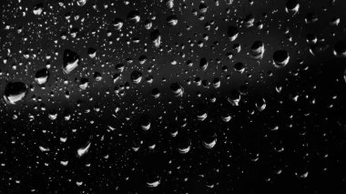 Islak cam. Su damlacıkları. Kapalı camlara yağmur damlaları düşer. Seçici odak siyah ve beyaz