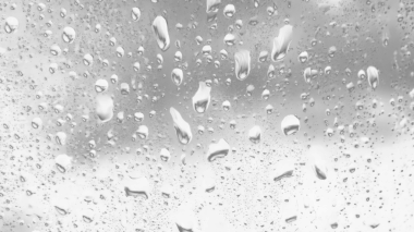 Islak cam. Su damlacıkları. Kapalı camlara yağmur damlaları düşer. Seçici odak siyah ve beyaz