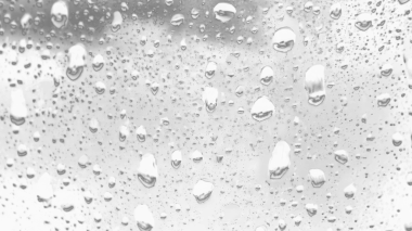 Islak cam. Su damlacıkları. Kapalı camlara yağmur damlaları düşer. Seçici odak siyah ve beyaz