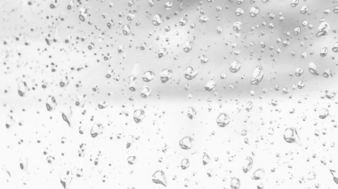 Islak cam. Su damlacıkları. Kapalı camlara yağmur damlaları düşer. Seçici odak siyah ve beyaz