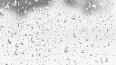 Islak cam. Su damlacıkları. Kapalı camlara yağmur damlaları düşer. Seçici odak siyah ve beyaz