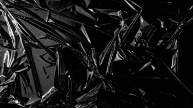 Plastik ambalaj dokusu siyah arkaplan üzerinde kaplama etkisi. Gizlenmek için plastik kolları küçült. Beyaz plastik