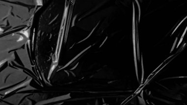 Plastic wrap texture overlay effect on black background. Shrink wrapped plastic sleeve for cover. White plastic