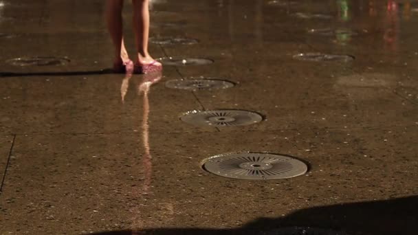 Movimiento lento de la persona con pantalones caminando a través de la fuente de agua del piso — Vídeo de stock