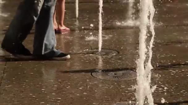 Slow motion of legs of people walking by floor water fountain — Stock Video