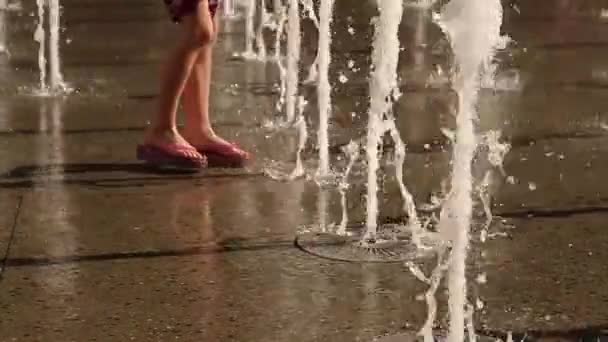 Slow motion of floor water fountain jets with person walking to them — Stock Video