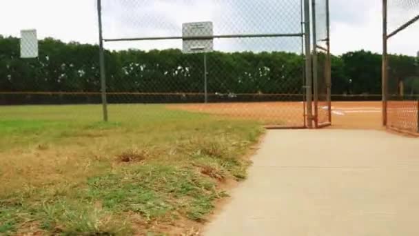 Prise de vue Steadicam d'un terrain de baseball pris par derrière une clôture — Video