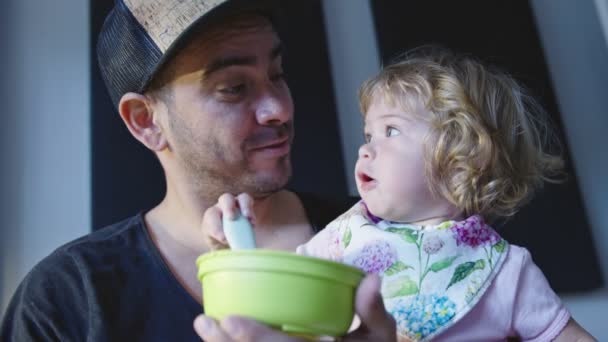 Ojciec i córeczka robią śmieszne miny podczas karmienia — Wideo stockowe