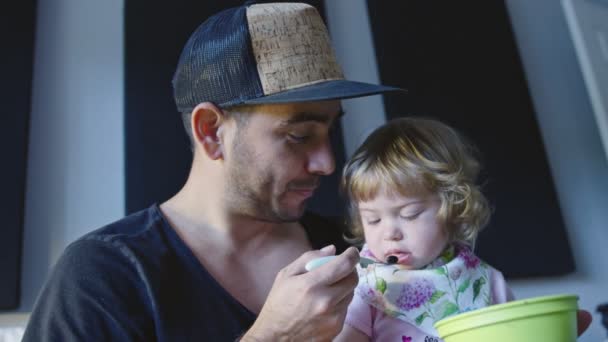Отец кормит прекрасную маленькую дочь — стоковое видео