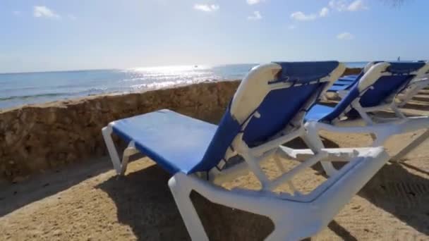 Strand/nyugágyak a tengerparton, egy világos napsütéses napon — Stock videók