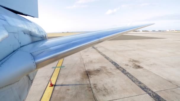 Боковой снимок крыла самолета на взлетно-посадочной полосе — стоковое видео