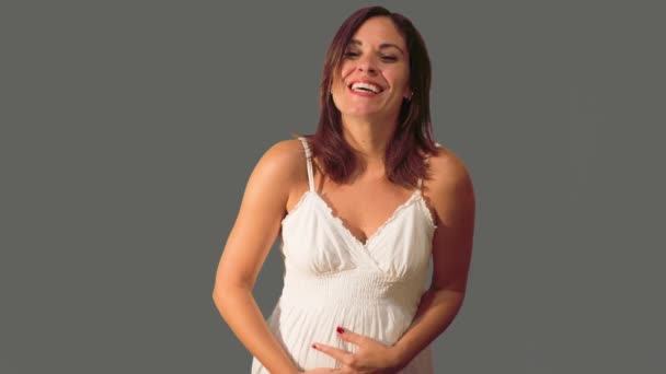 Красивая беременная женщина держит живот и улыбается . — стоковое видео
