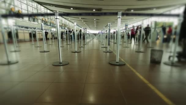 Зона регистрации в терминале аэропорта без линий. Несколько человек ходят вокруг . — стоковое видео