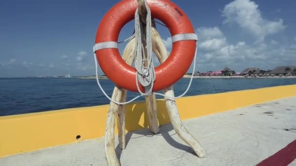 Shot of a lifesaver personal flotation device by the ocean water. — Stock Video