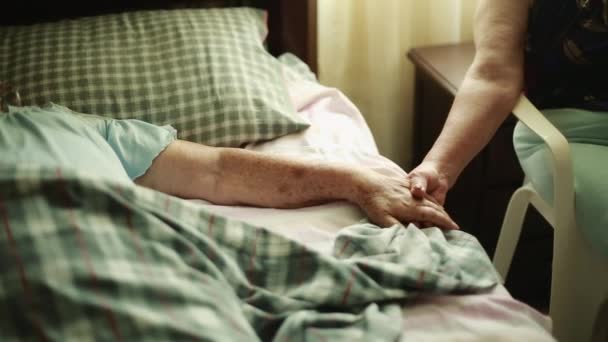 老年妇女躺着和另一个女人的手牵着手 — 图库视频影像