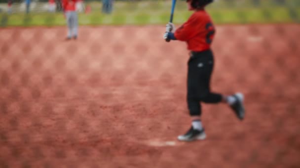Kid batendo e correndo no jogo de beisebol — Vídeo de Stock