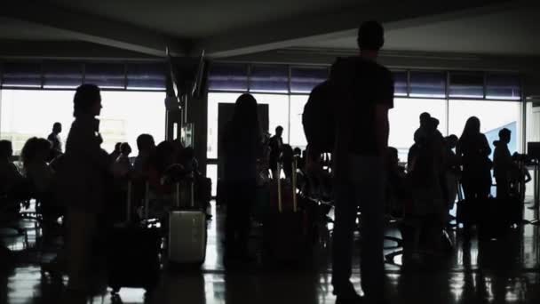 Силуэт людей, ожидающих в терминале аэропорта — стоковое видео