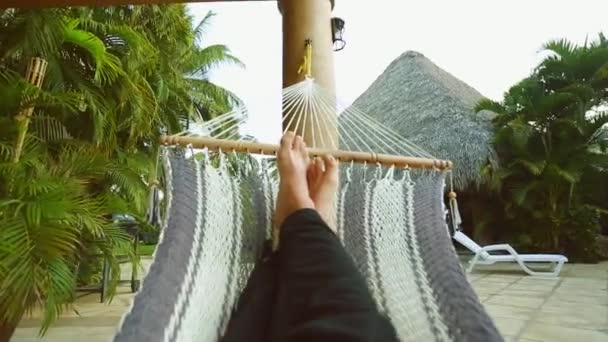 Person's legs resting on Hammock at beautiful vacation spot — Stock Video