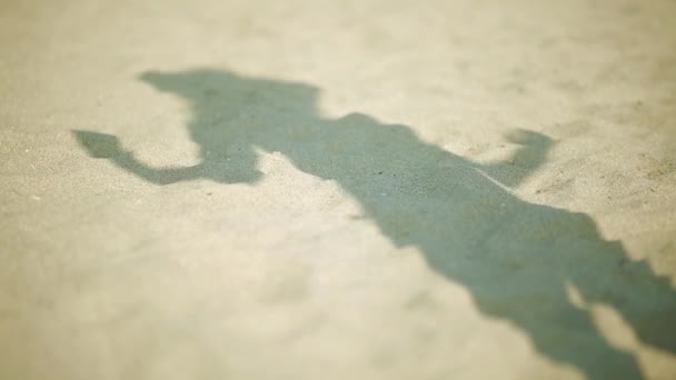 Vrouw schaduw op het zand op het strand als ze dansen — Stockvideo