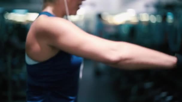 Mujer levantando pesas en el gimnasio, ejercitando sus brazos — Vídeo de stock