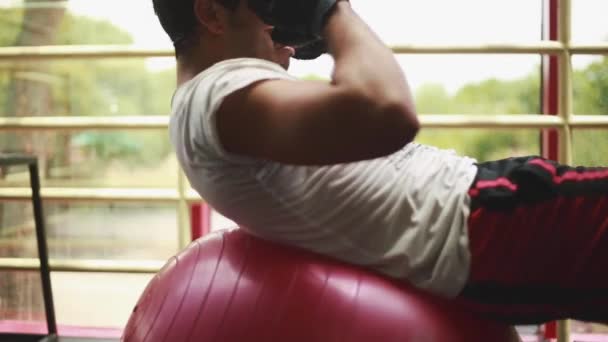 Tiro legal de homem fazendo abdominais em cima da bola de ginásio — Vídeo de Stock